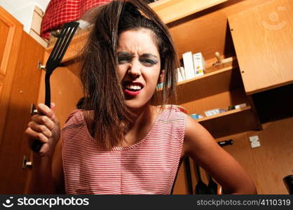 Young woman brandishing a fish slice