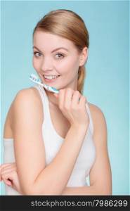 Young woman brushing cleaning teeth. Girl holds toothbrush with toothpaste on it. Oral hygiene.