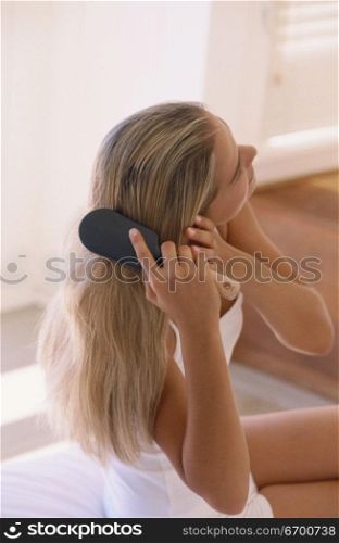 Young woman brushing her hair