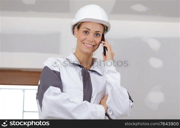 young woman builder on the phone