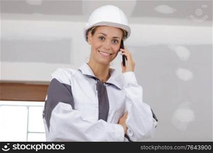 young woman builder on the phone