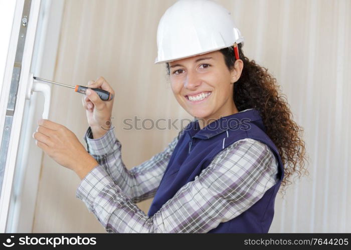 young woman builder working using a screwdriver