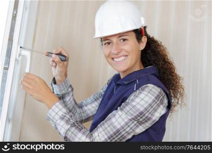 young woman builder working using a screwdriver