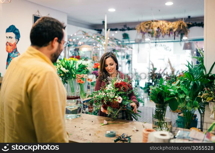 Young woman buying a bouquet of flowers in a florist