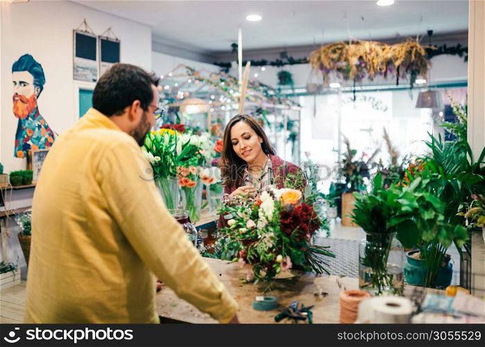 Young woman buying a bouquet of flowers in a florist