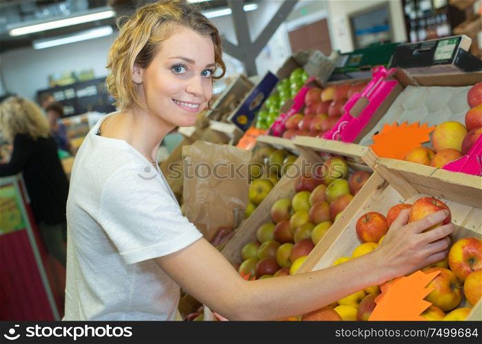 young woman buying apple on the market