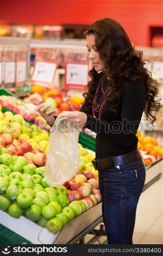 Young woman buying fruits in the supermarket