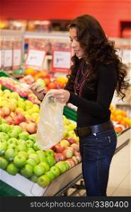 Young woman buying fruits in the supermarket