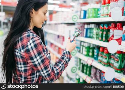 Young woman buying toothbrush in supermarket. Female customer on shopping in hypermarket, department of personal care products