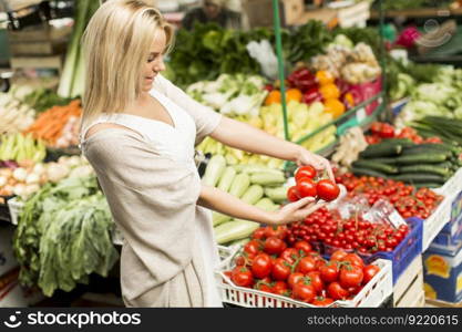 Young woman buying vegetables at the market