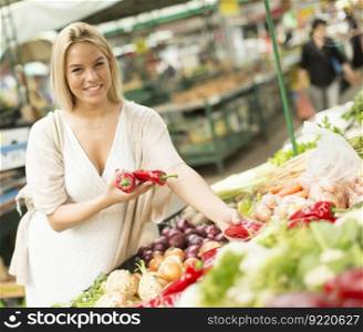 Young woman buying vegetables at the market