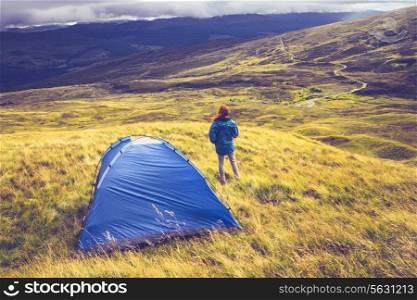 Young woman camping in the mountains