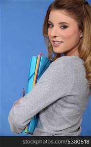 Young woman carrying folders