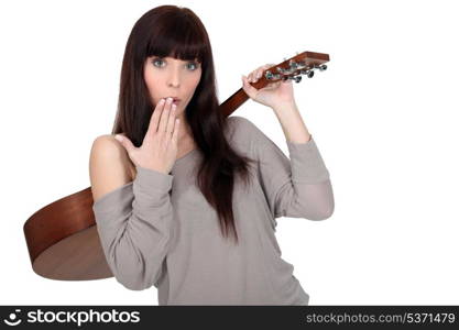 young woman carrying guitar over shoulder with hand before mouth
