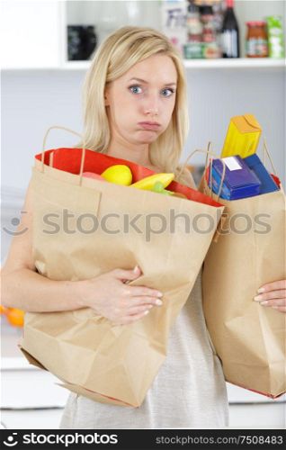 young woman carrying heavy shopping bags