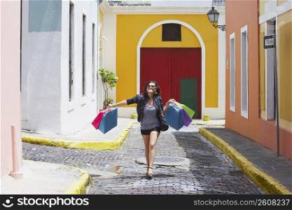Young woman carrying shopping bags and smiling, Old San Juan, San Juan, Puerto Rico