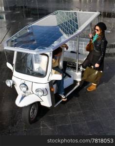 Young woman catching a ride in a solar powered tuc tuc