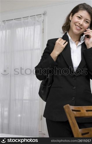 Young woman chatting on cell phone while leaving for work