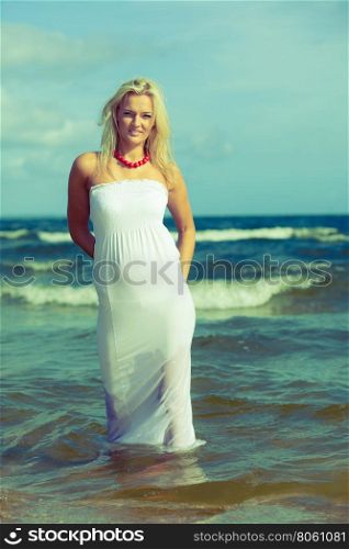 Young woman chilling out on the beach.. Leisure spare time activities. Young woman chilling out on the beach. Lady spending free moments outside. Attractive girl has white dress.