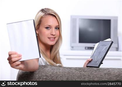Young woman choosing a DVD with a case left blank for your message