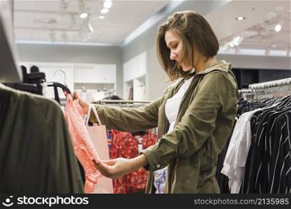 young woman choosing different outfits