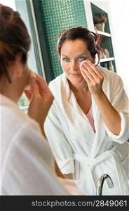 Young woman cleaning face cotton pads bathrobe bathroom morning preparation