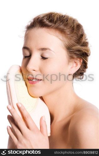 Young woman cleaning face with sponge isolated on white
