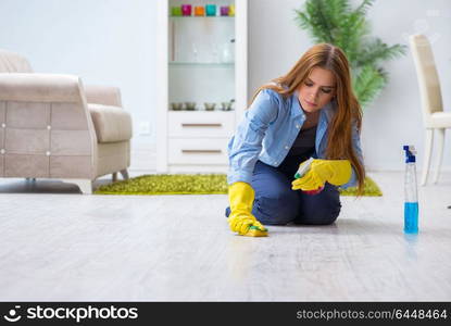 Young woman cleaning floor at home doing chores