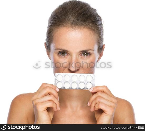 Young woman close mouth with pack of pills
