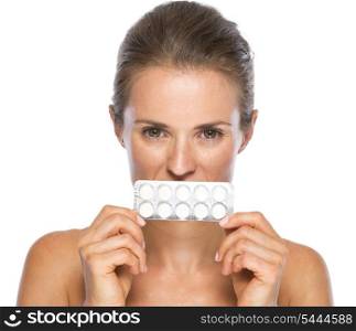 Young woman close mouth with pack of pills