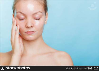 Young woman closed eyes in facial peel off mask. Peeling. Beauty and skin care. Studio shot on blue background. Woman in facial peel off mask.