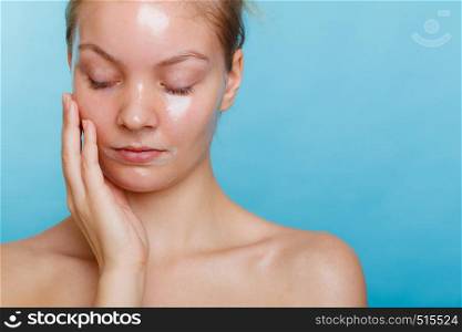 Young woman closed eyes in facial peel off mask. Peeling. Beauty and skin care. Studio shot on blue background. Woman in facial peel off mask.
