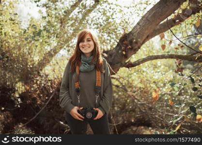 Young woman closeup with old film camera in her hip in the forest. Young woman closeup with old film camera in her hip