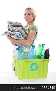 young woman collecting paper and plastic for recycling