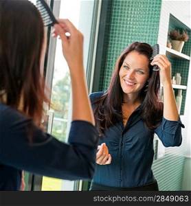 Young woman combing hair comb mirror bathroom morning preparation