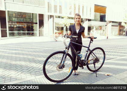 Young woman commuting on bicycle. Young woman in business wear commuting on bicycle in city