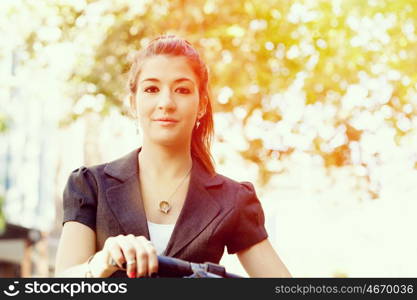 Young woman commuting on bicycle. Young woman in business wear commuting on bicycle in city