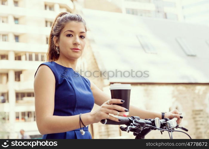 Young woman commuting on bicycle. Young woman in business wear commuting on bicycle in city