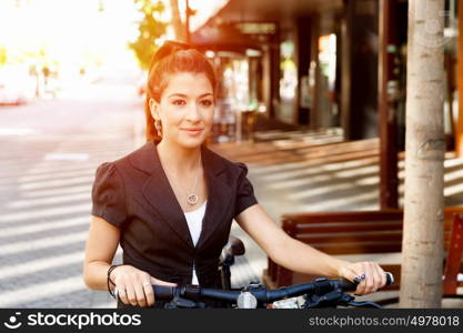 Young woman commuting on bicycle. Young woman in business wear commuting on bicycle in city