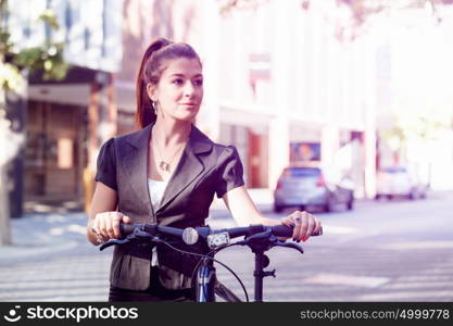 Young woman commuting on bicycle. Young woman in business wear commuting on bicycle in city