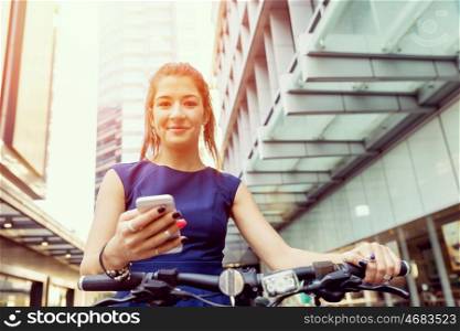 Young woman commuting on bicycle. Young woman in business wear on bicycle with a cup of coffee