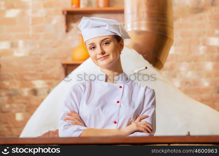 Young woman cook. Image of young woman cook standing at kitchen