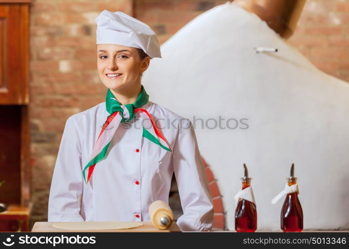 Young woman cook. Image of young woman cook standing at kitchen