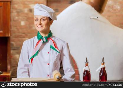 Young woman cook. Image of young woman cook standing at kitchen