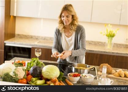 Young woman cooking healthy food in the modern kitchen