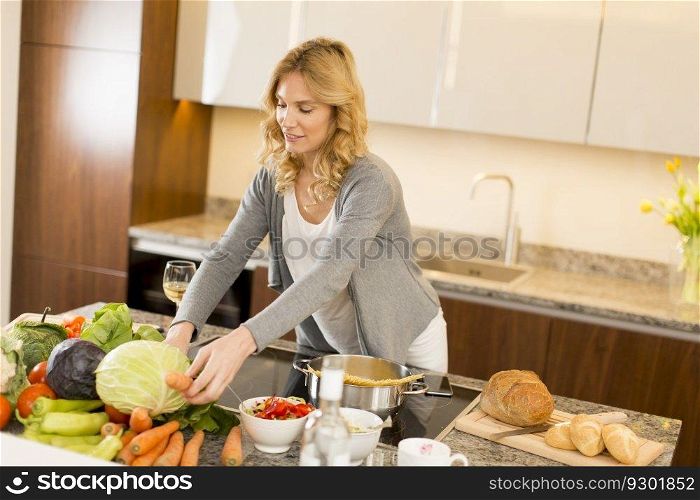 Young woman cooking healthy food in the modern kitchen