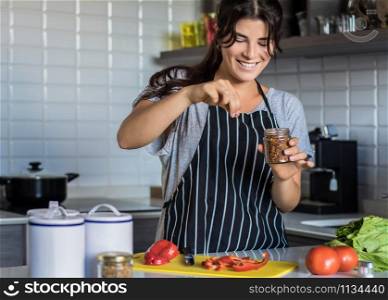 Young Woman Cooking in the kitchen at home. Healthy Food.