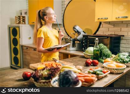 Young woman cooking on recipes, healthy eco food. Vegetarian diet, fresh vegetables and fruits