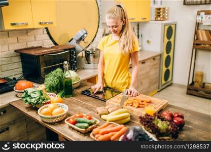 Young woman cooking on recipes, healthy food. Vegetarian diet, fresh vegetables and fruits. Young woman cooking on recipes, healthy food