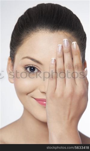 Young woman covering her half face with hand